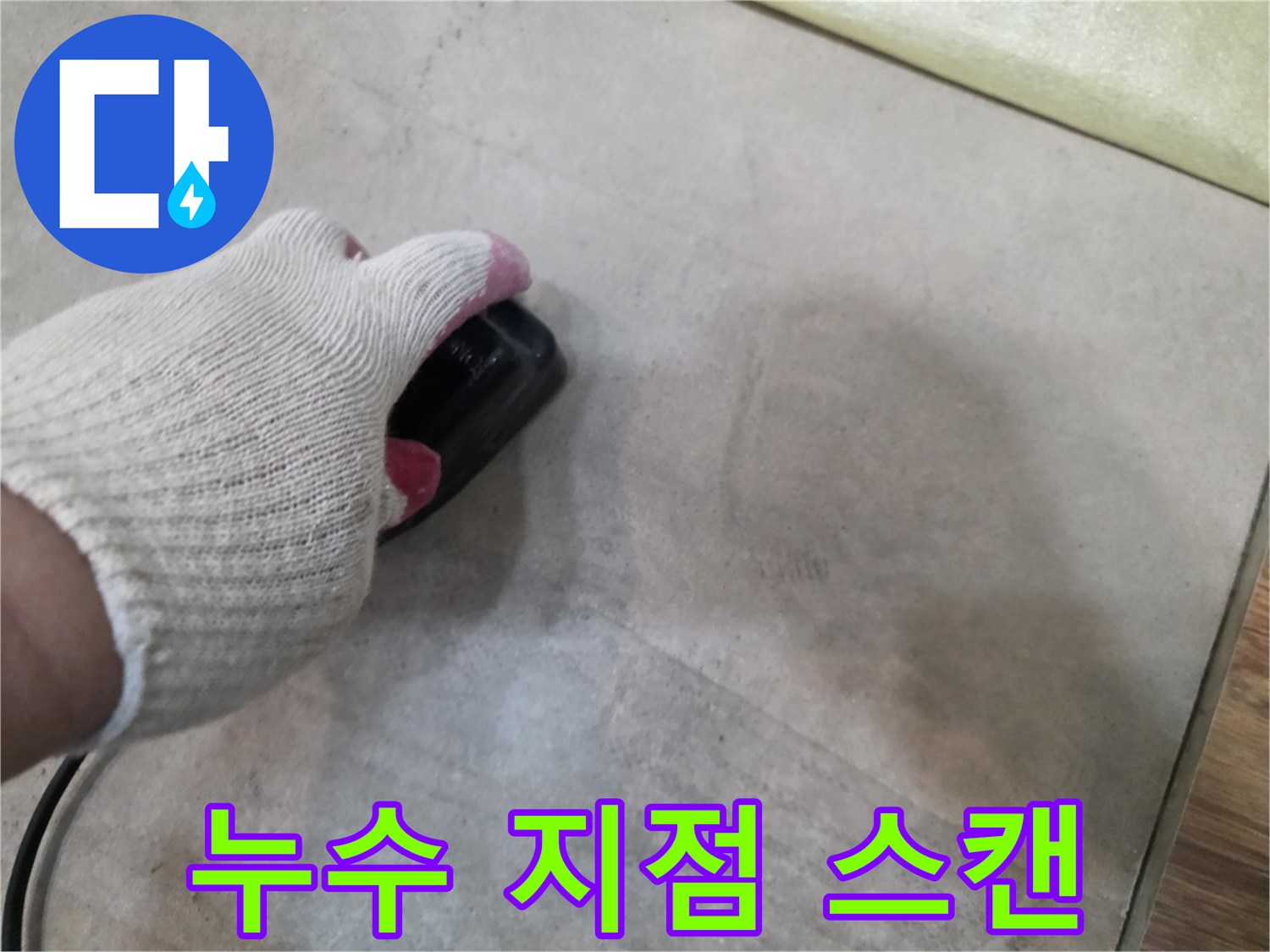 장갑 낀 손으로-탐지기를-바닥에-대고 움직이는 장면