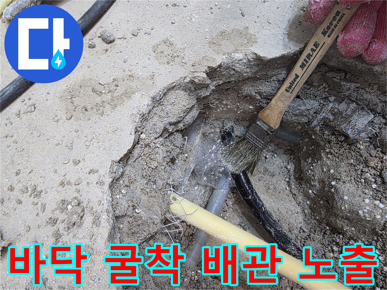 콘크리트 층을 굴착하여 드러난 노란색 배관과 검은색 호스 상태