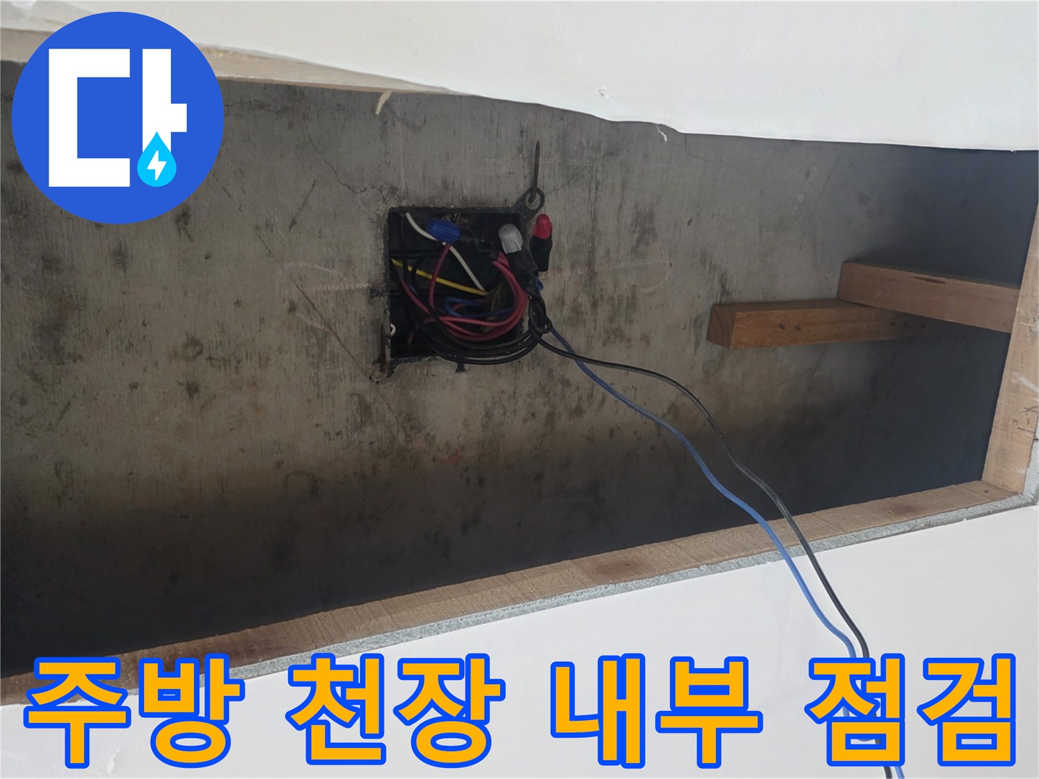 천장 틈새로 보이는 전기 배선 박스와 목재 구조물 프레임