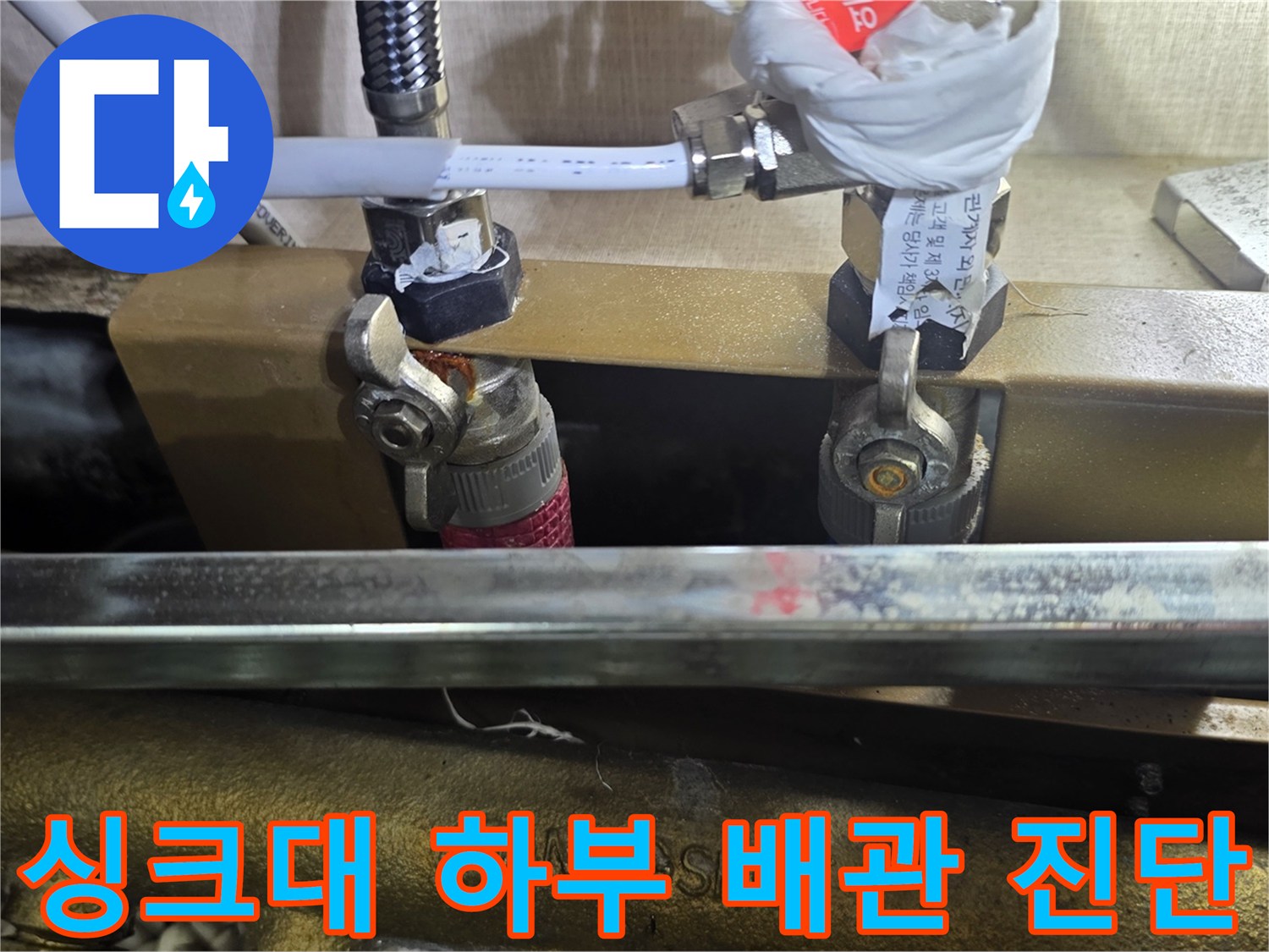 배관-압력-게이지와-연결-호스가-설치된-싱크대-하부-모습