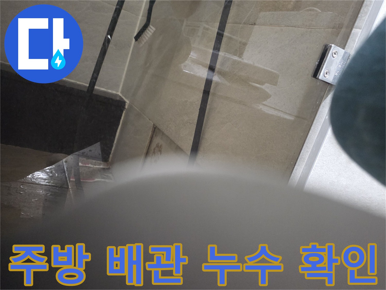 싱크대 밑 배관 연결 부위의 물샘 흔적을 촬영한 사진