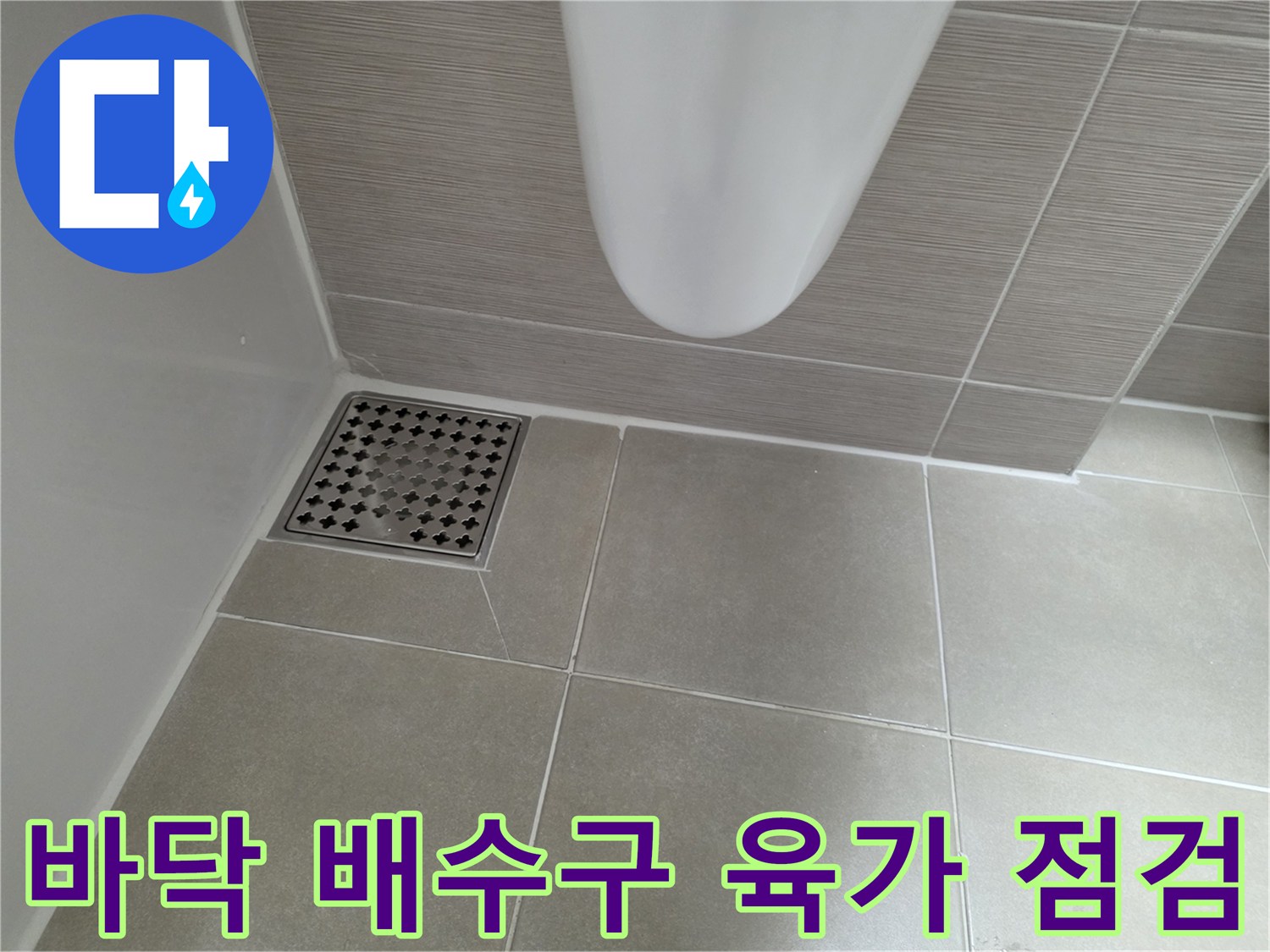 화장실 바닥의 금속제 배수구 덮개와 타일