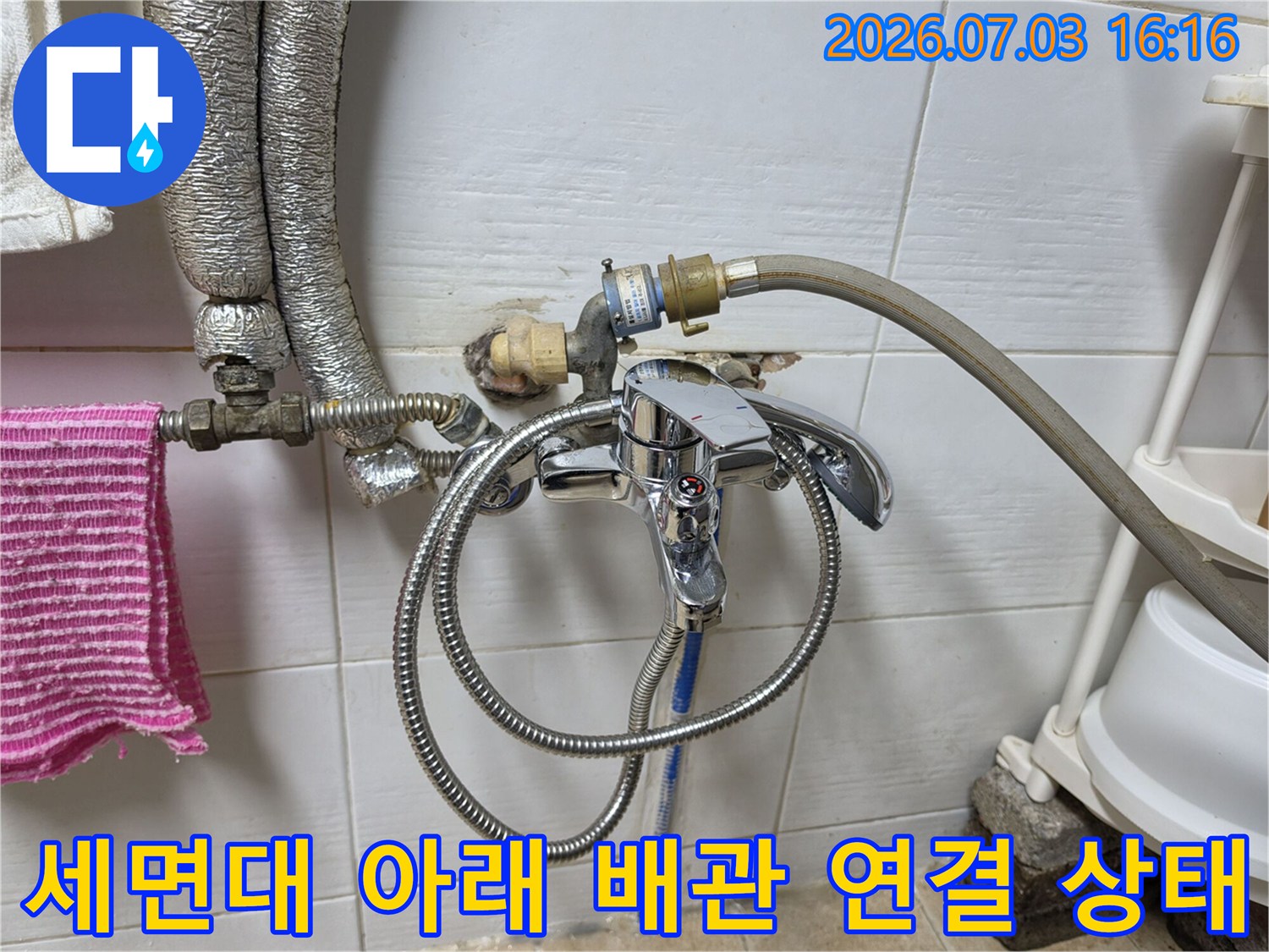 노출된 세면대 하부 배관과 호스 뭉치