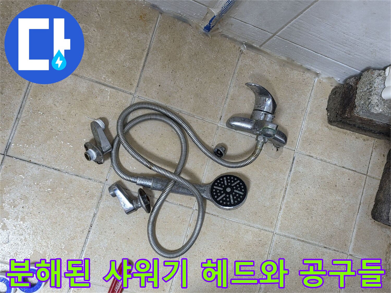 바닥에 놓인 탈거된 샤워기 부속과 작업용 공구