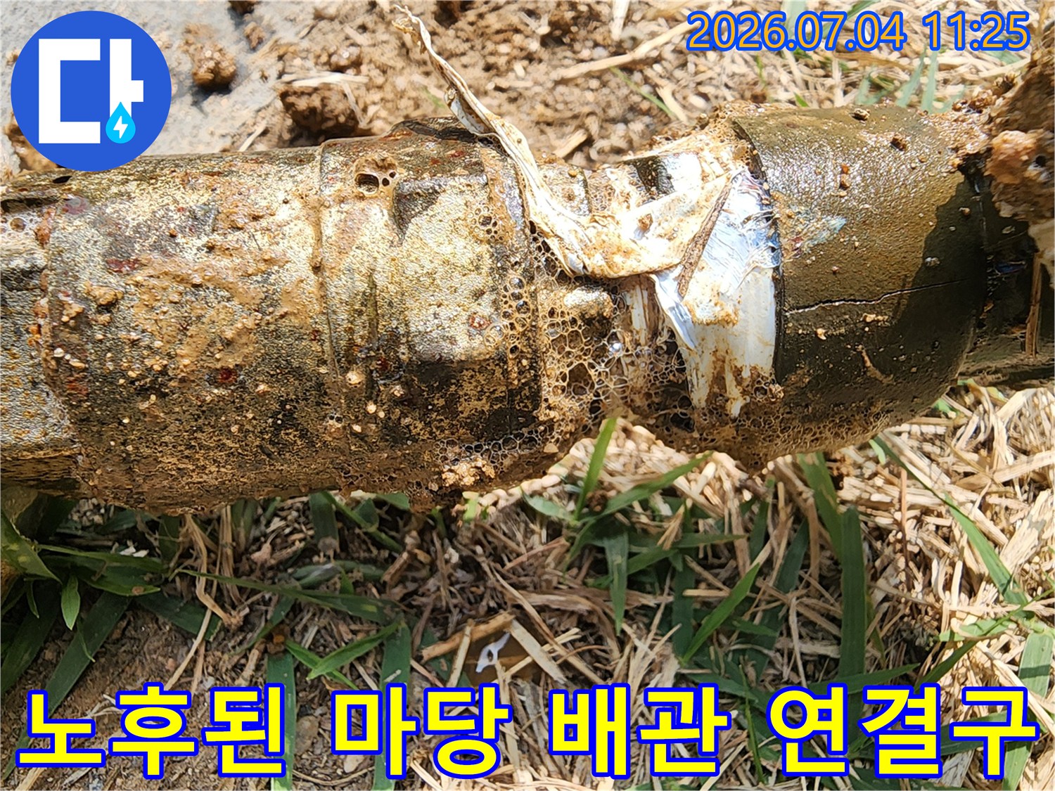 흙과 흙먼지가 묻은 노출형 수도 배관의 파손된 접합부 모습