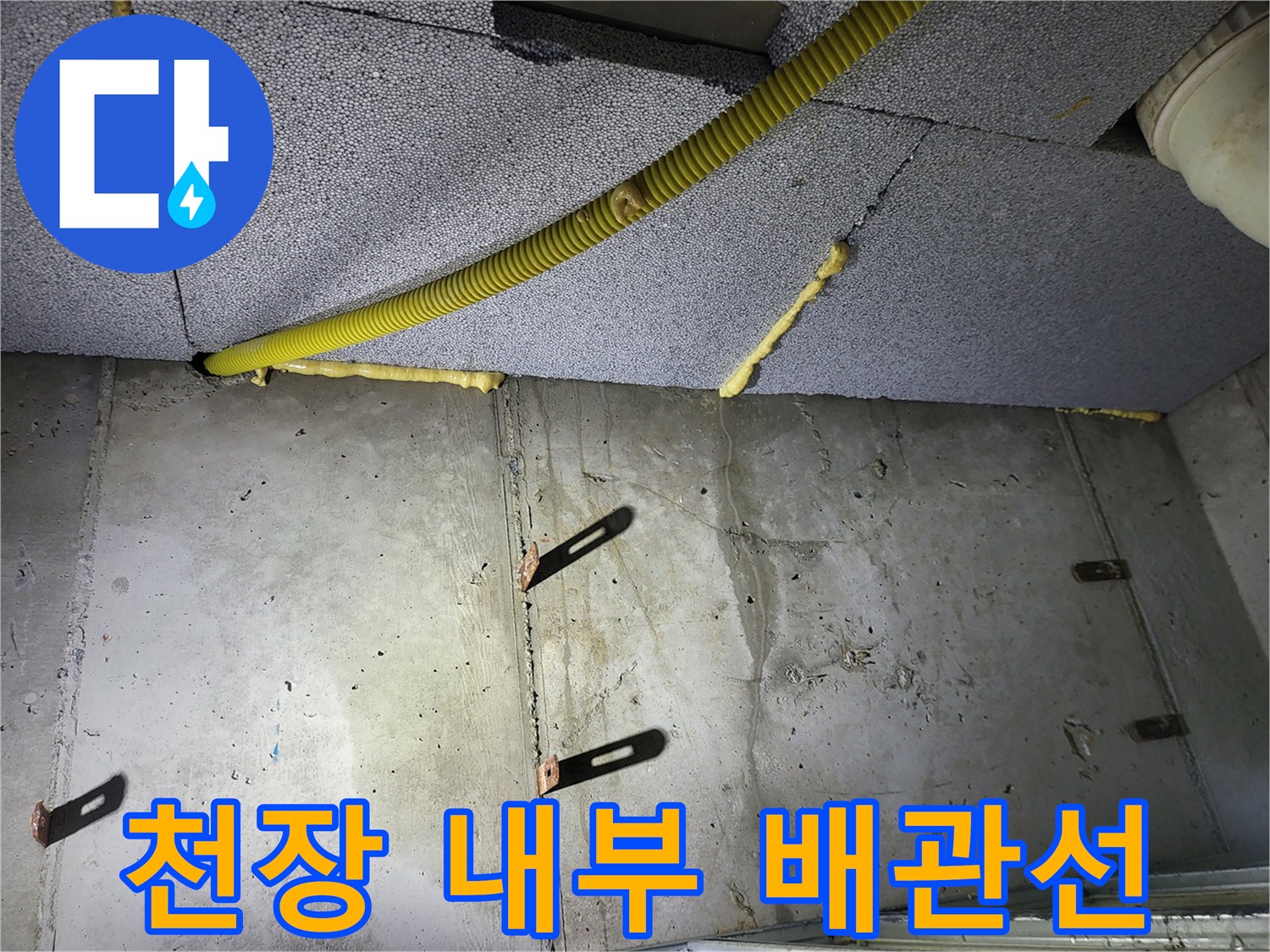 천장 단열재 사이로 보이는-주름진 노란색 배관