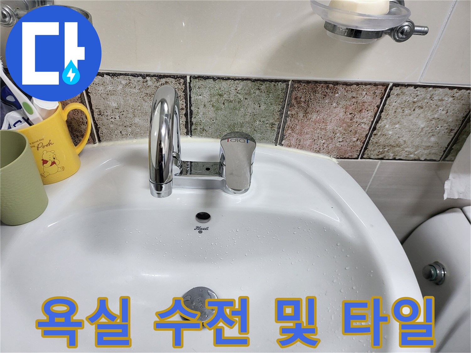 깨끗하게 정리된 세면대 수전과 욕실 타일 벽면