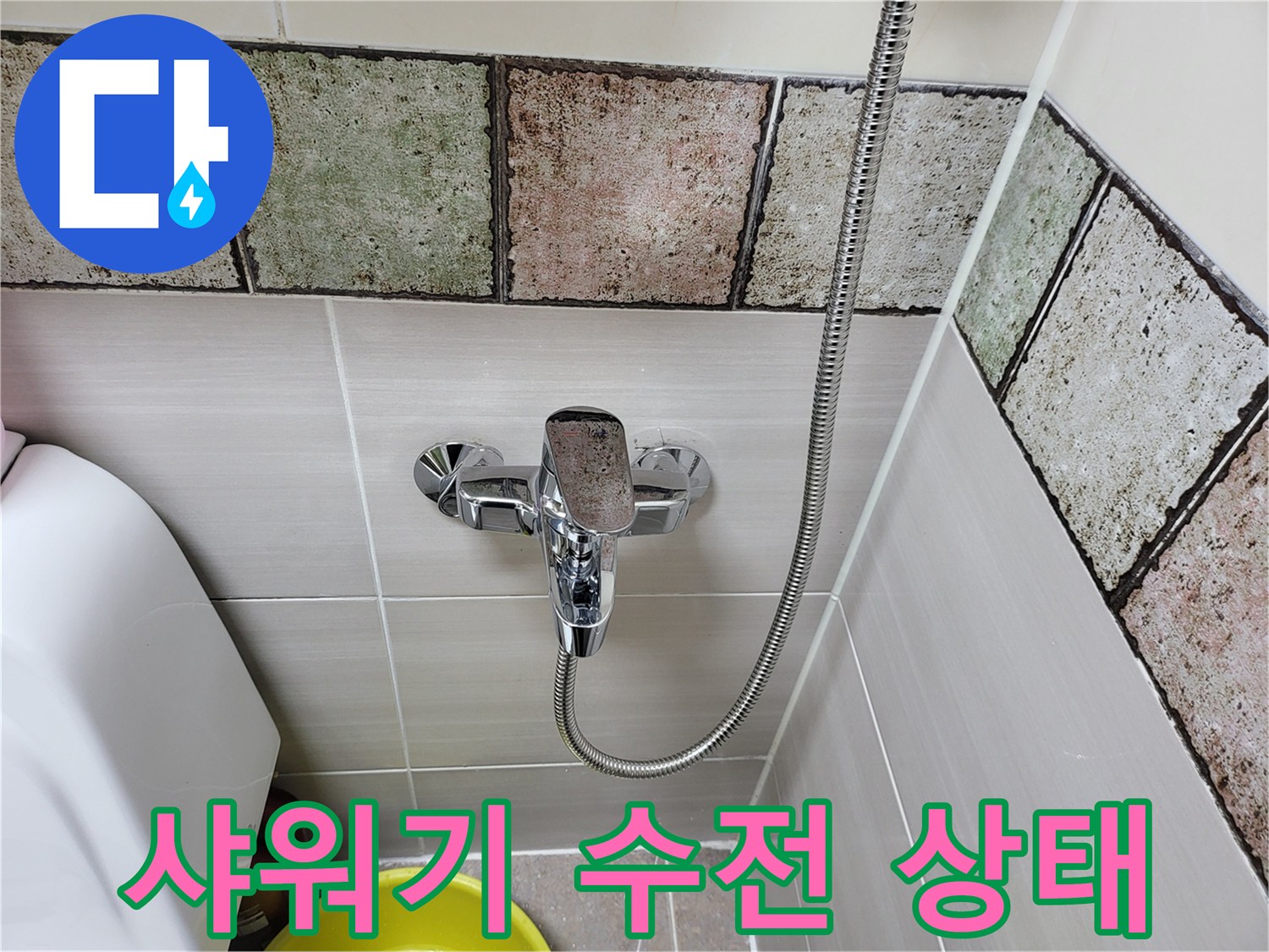욕실 벽면에 설치된 크롬 도금 샤워기 수전의 모습입니다.