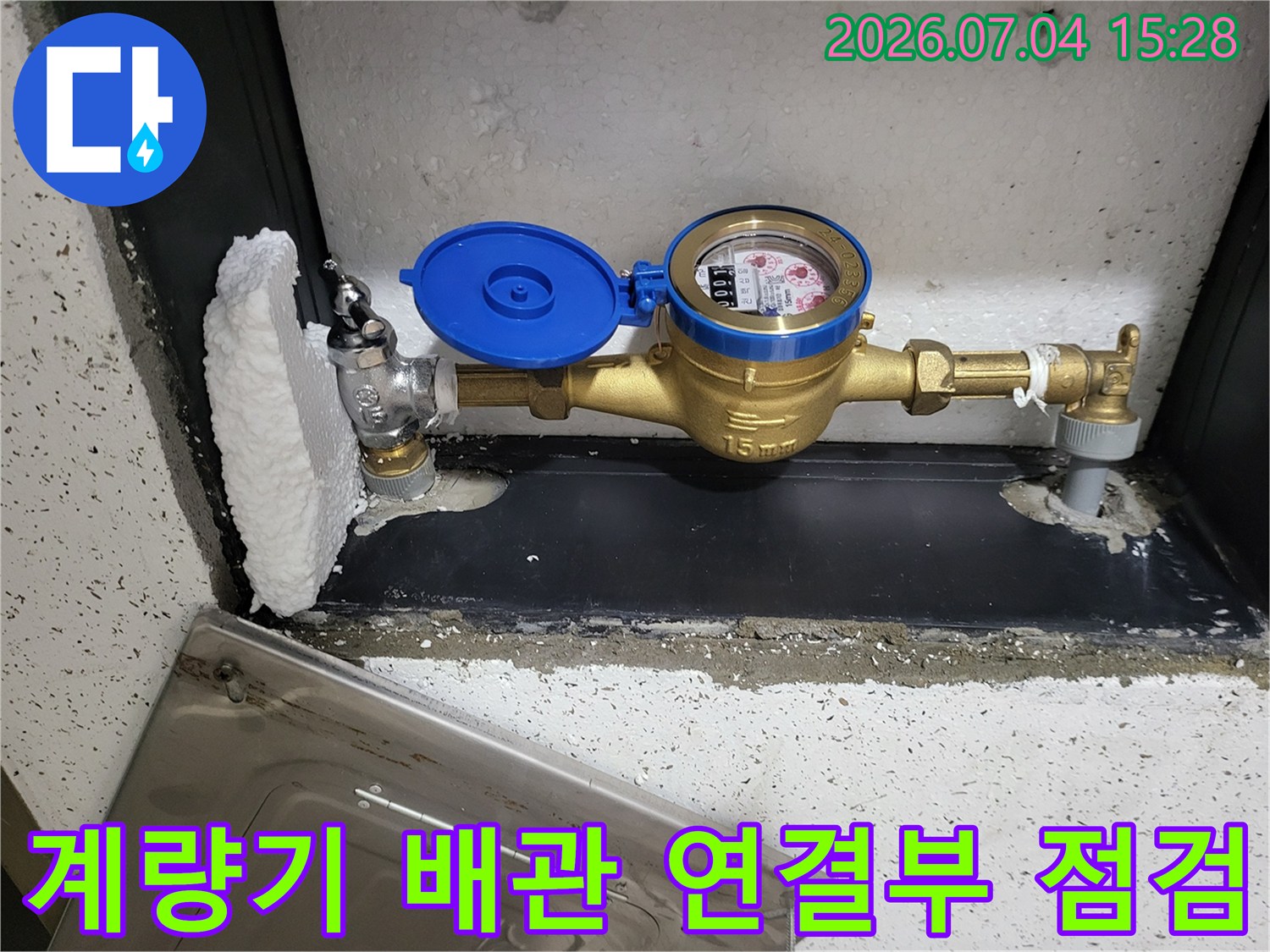황동 밸브와 파란색 계량기가 포함된 수전용 배관 구조