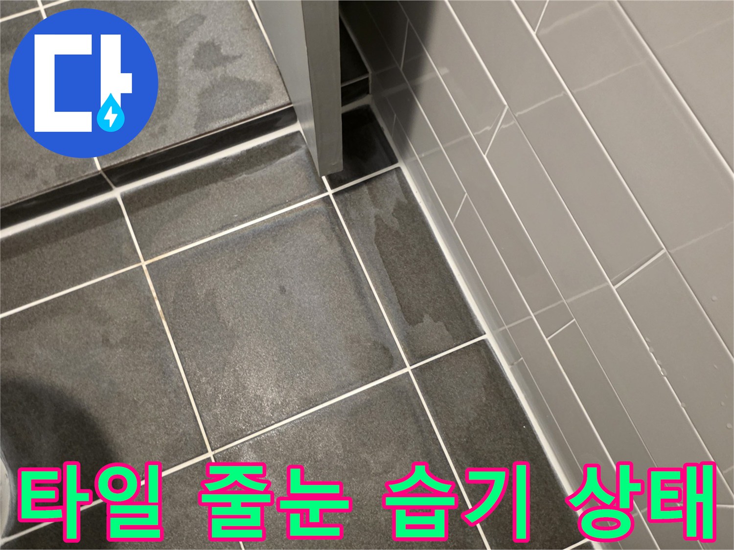 어두운 회색 타일 사이의 젖은 줄눈 부위