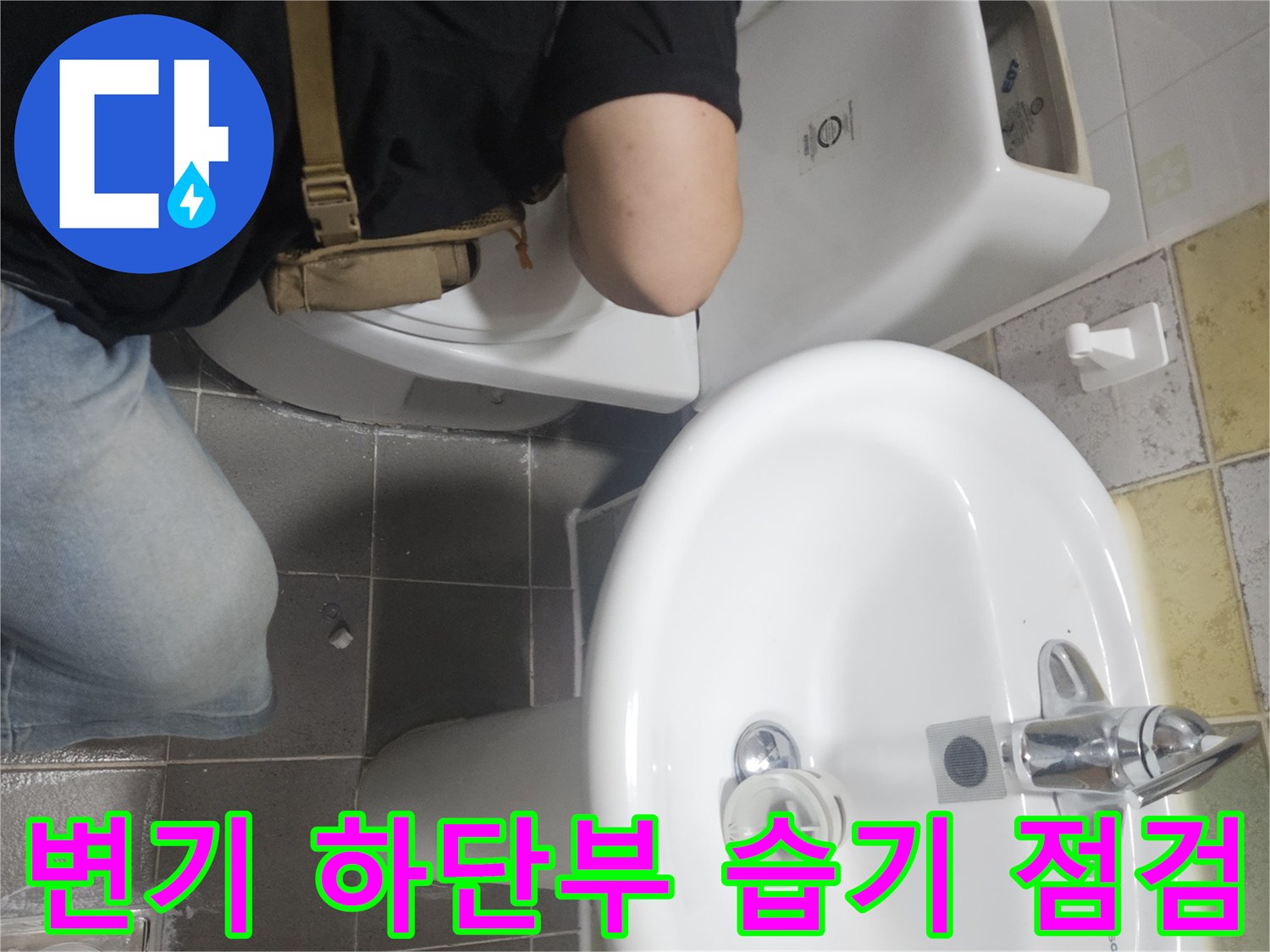 변기와 세면대 사이 타일 틈의 물 고임 현상을 조사하고 있습니다.