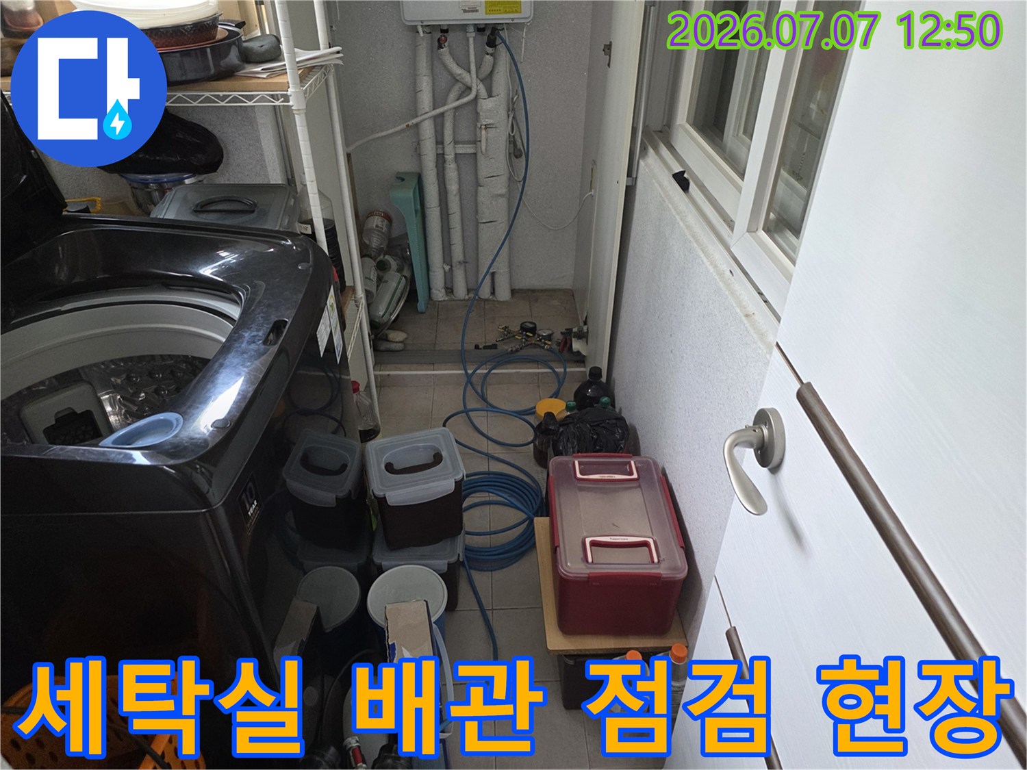 세탁기 옆에 배치된 장비와 노출된 수도 배관 시스템