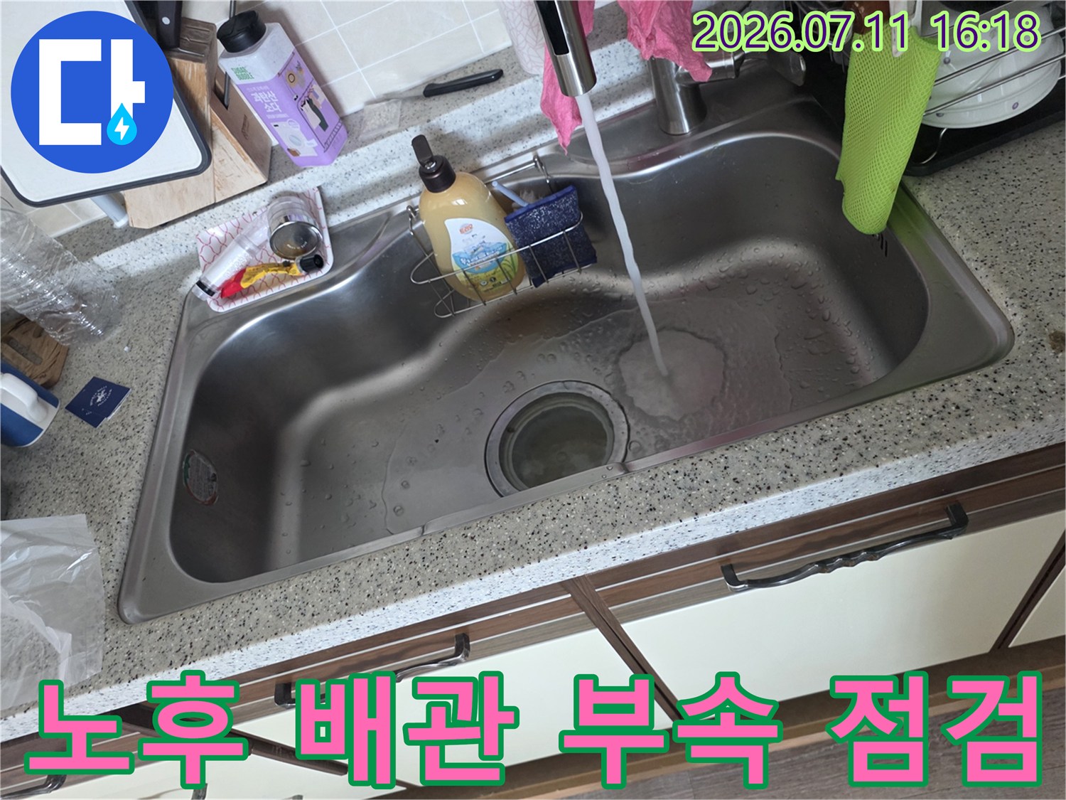 싱크대 아래 위치한 수전 연결용 커플러를 확인하는 작업 현장