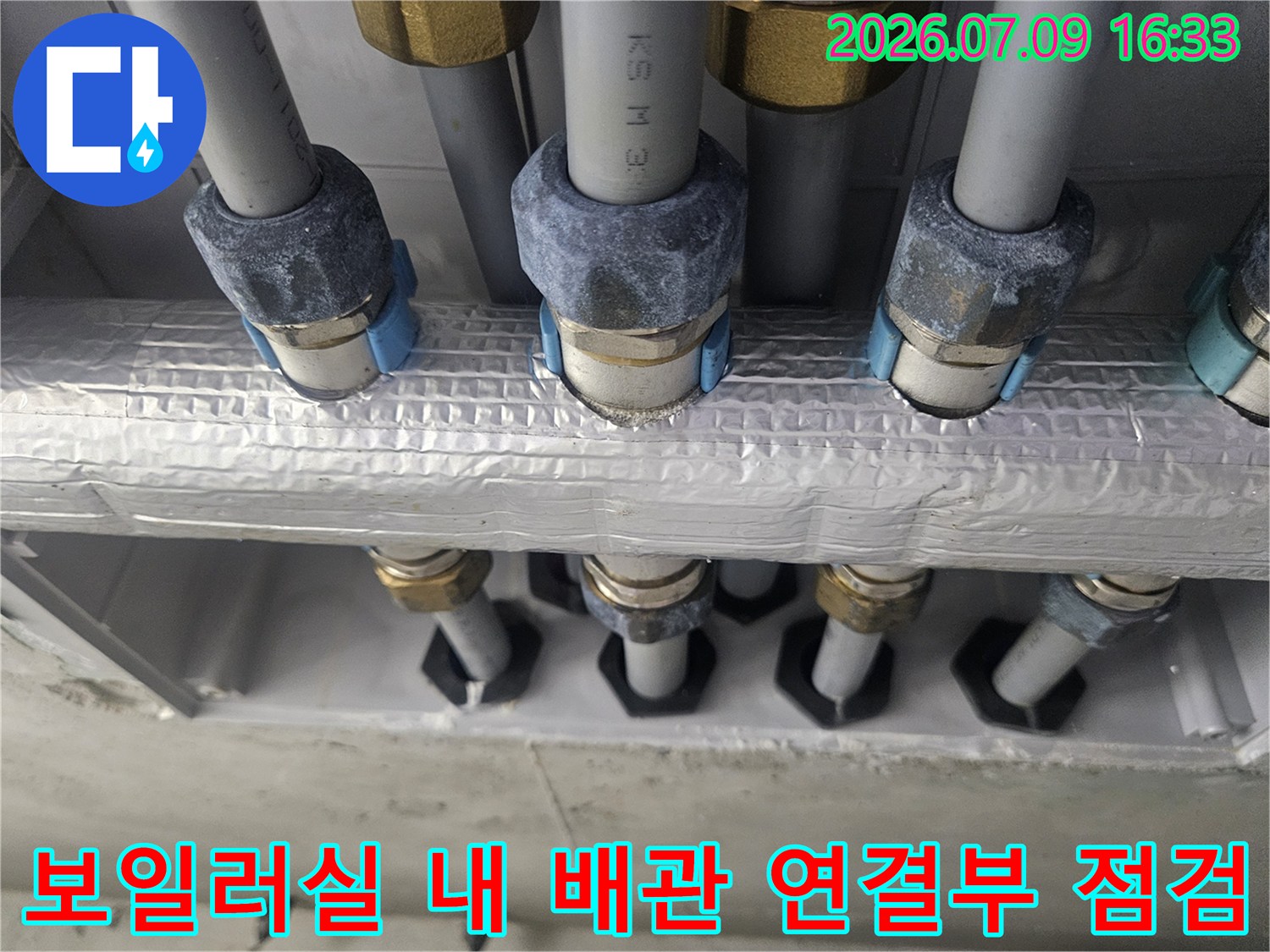 은박 단열재로 감싸진 다수의 배관과 그 연결 부위의 근접 촬영