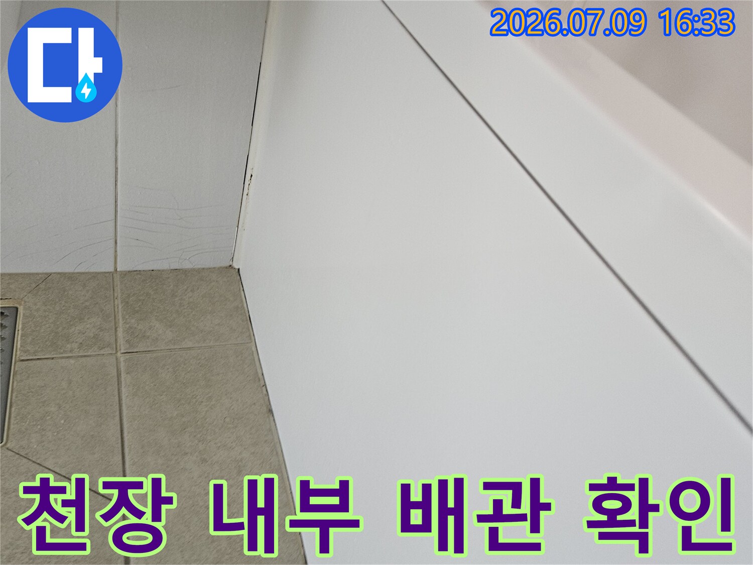 천장 마감재 안쪽의 흰색 판과 배관 연결 부위 촬영