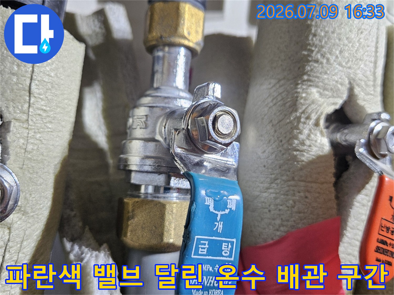 파란색 라벨링 된 밸브와 금속 파이프가 연결된 형태의 사진