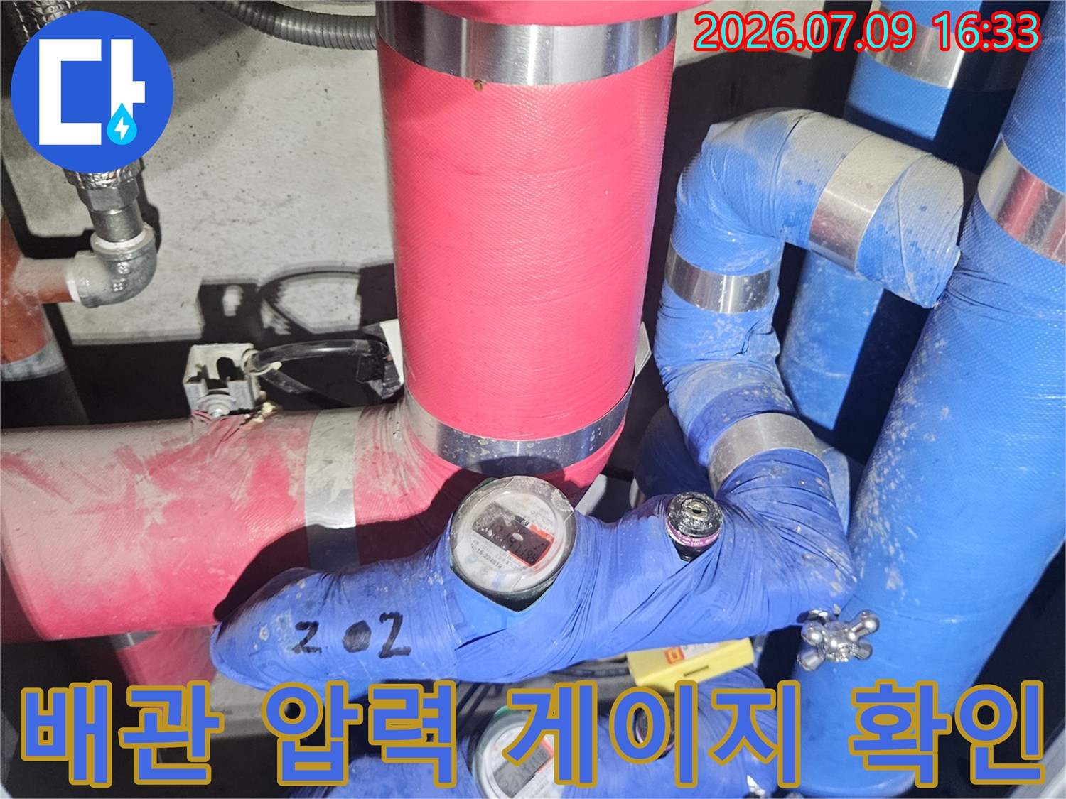 파란색 보온재로 감싸인 배관과 투명 덮개 내의 측정 장치
