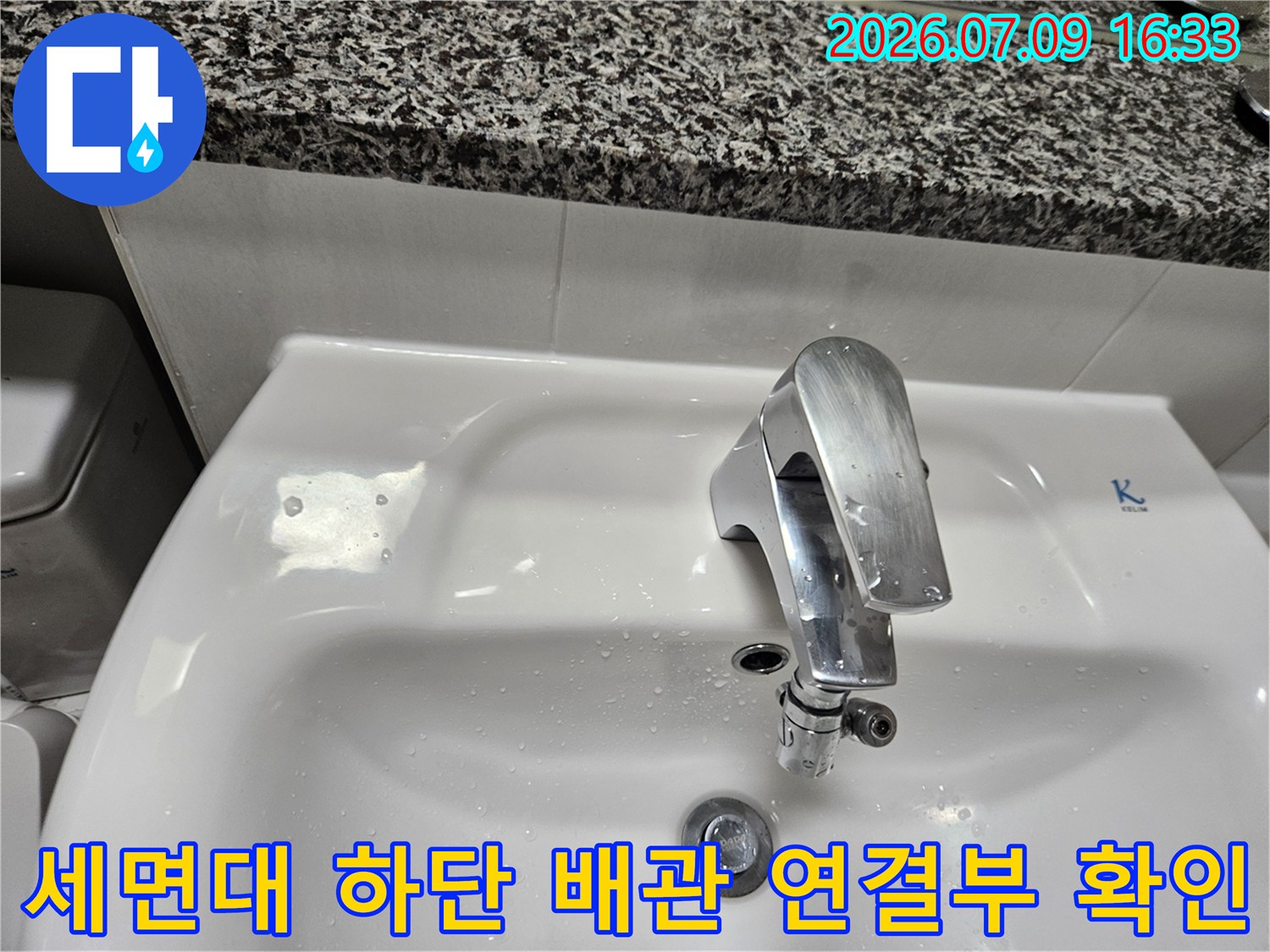 하얀색 세면대 아래 은색 수전과 연결된 배관 부위 상세 사진