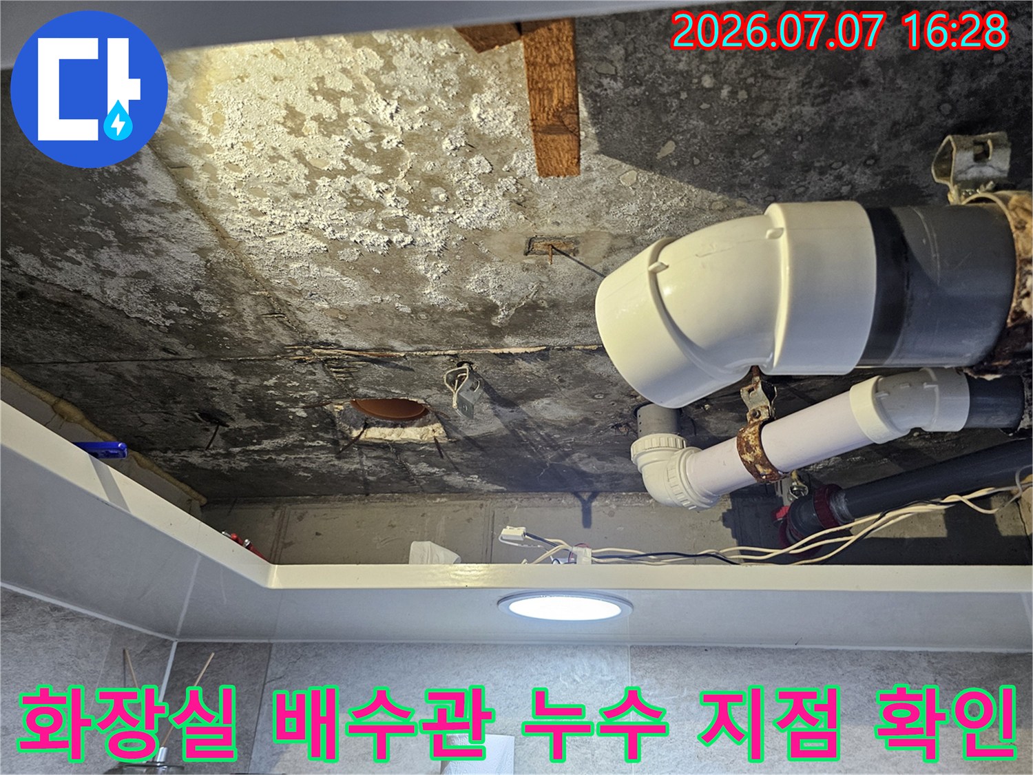 노후된 화장실 배수 배관의 연결 부위를 근접 촬영한 모습