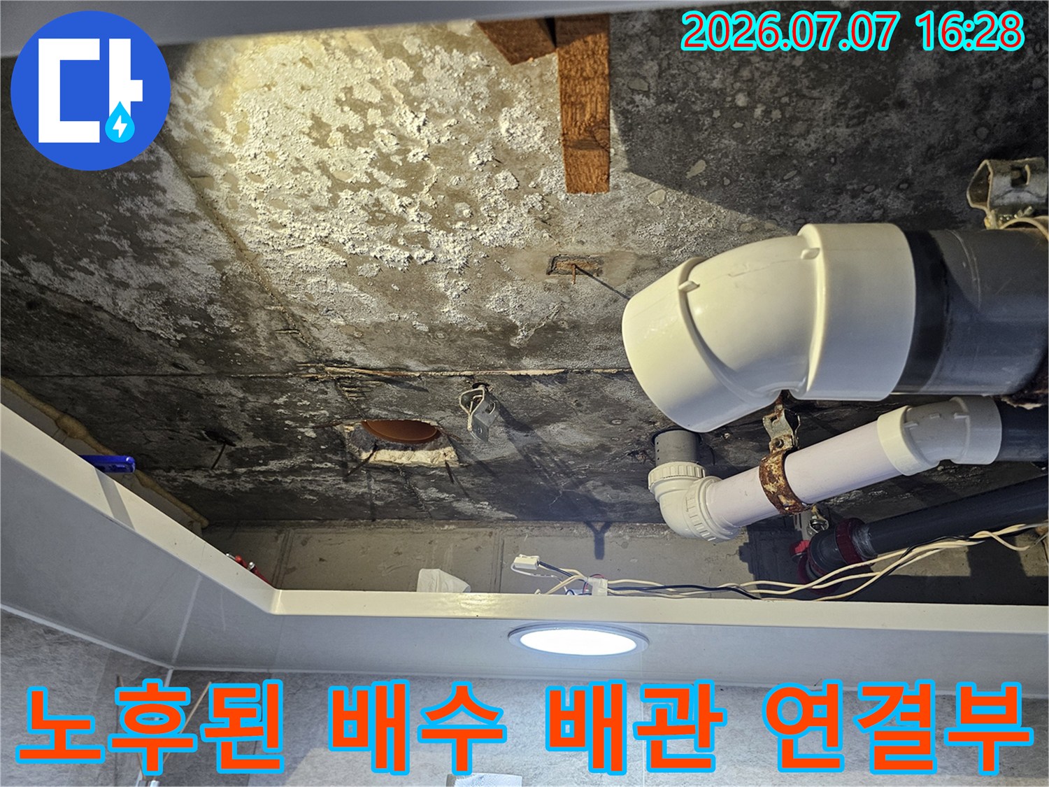 오염되고 노후된 화장실 천장 배수관의 연결 부위를 촬영한 사진