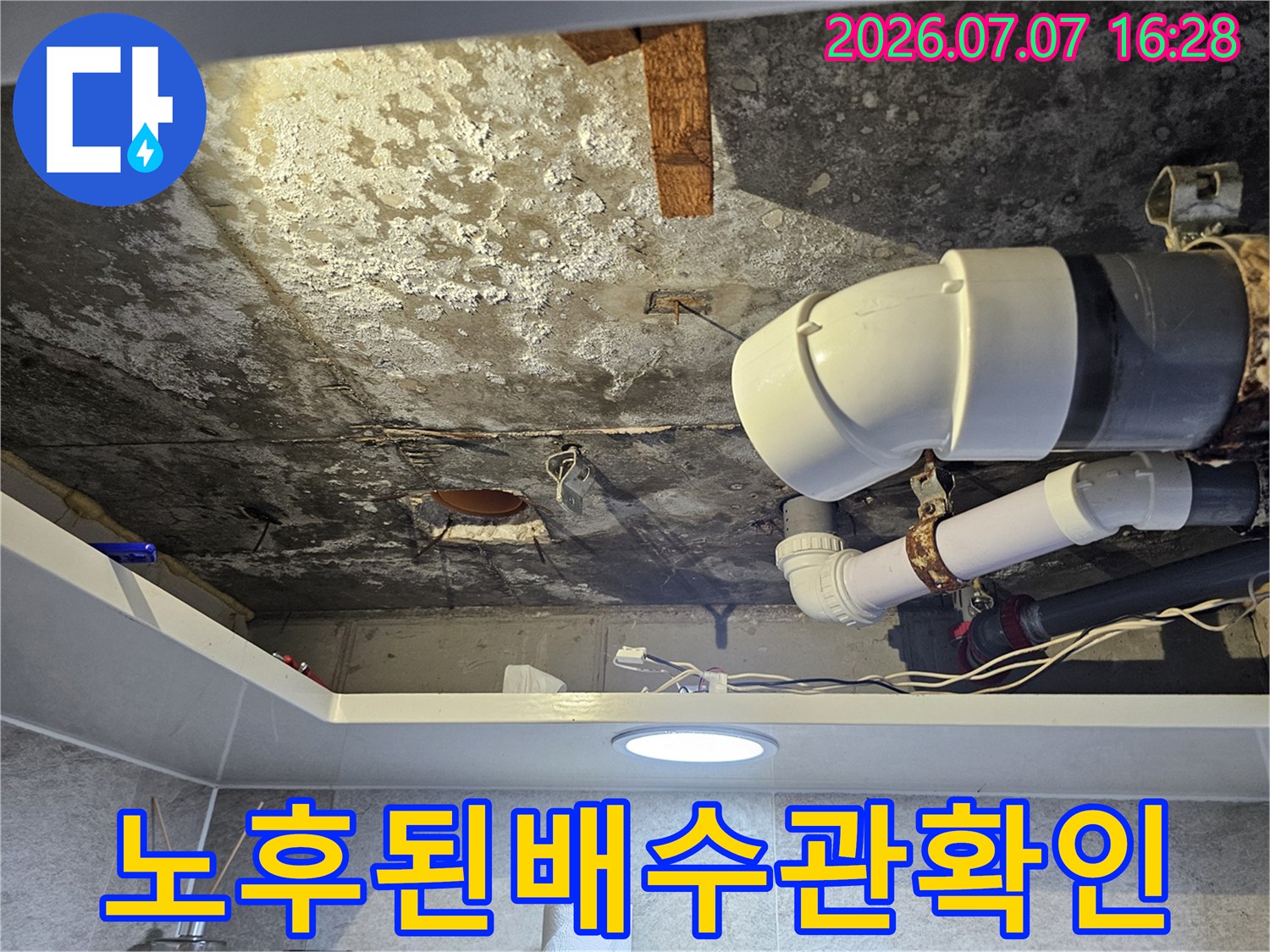 오염된 천장면과 노란색 배수 파이프 연결부 상태를 촬영한 사진