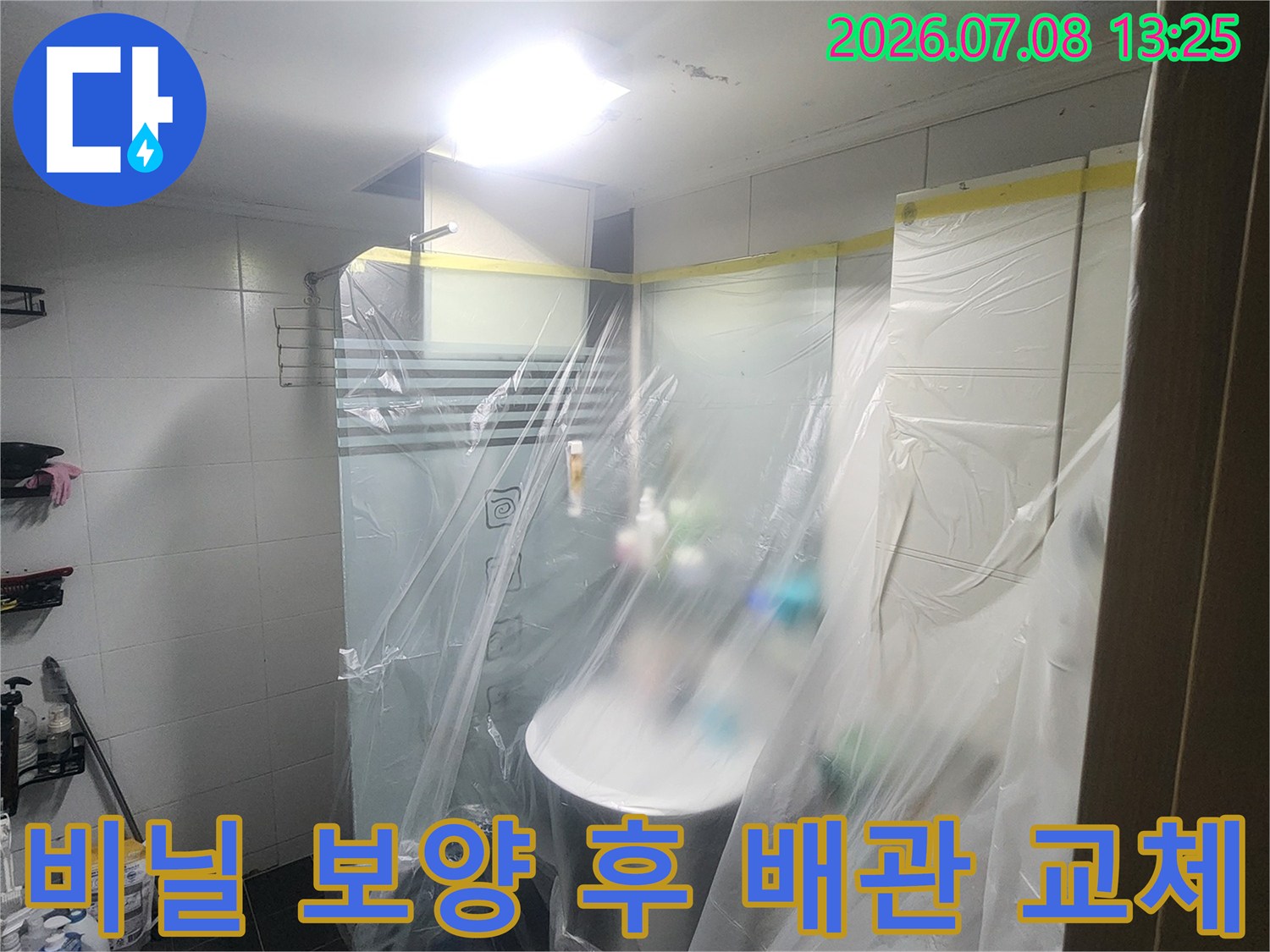 보호막 아래 숨겨진 파손된 하수관 부속을 수선하기 직전의 모습