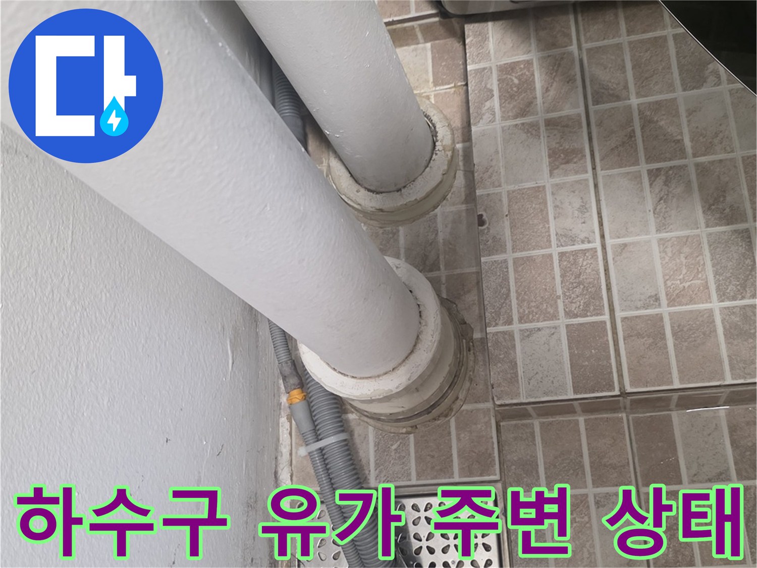 타일 바닥의 배수구와 수직 배관 사이의 구조적 모습