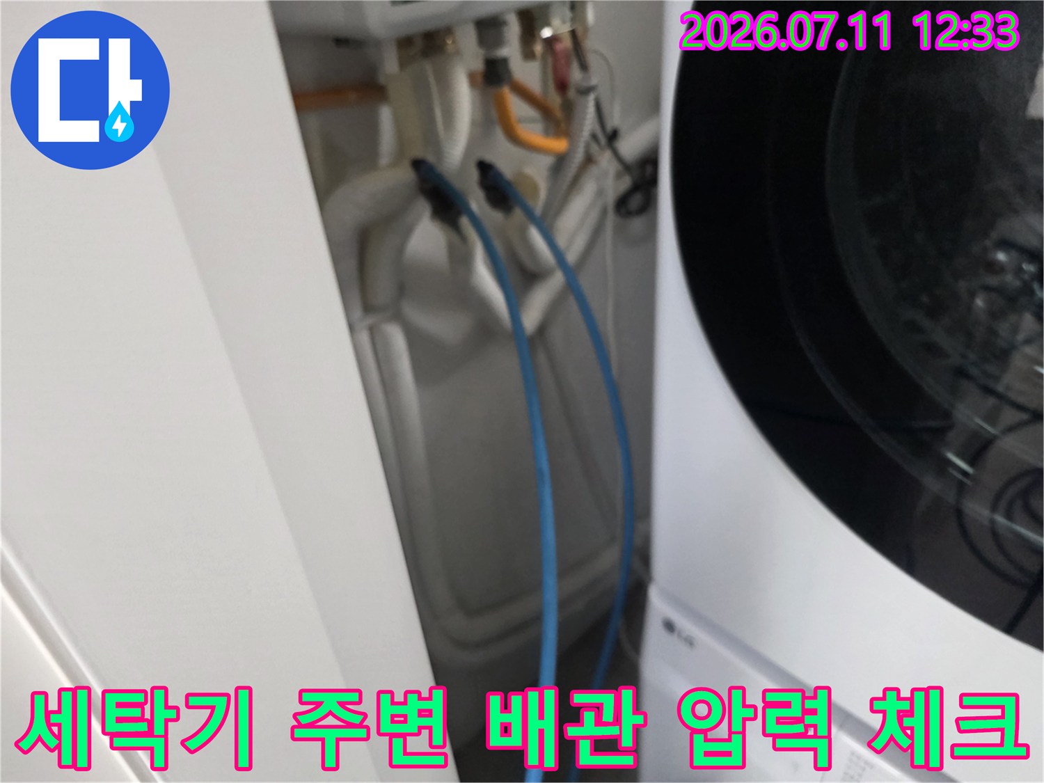세탁기 옆 파란색 호스로 연결된 수도 배관의 공압 테스트 장면