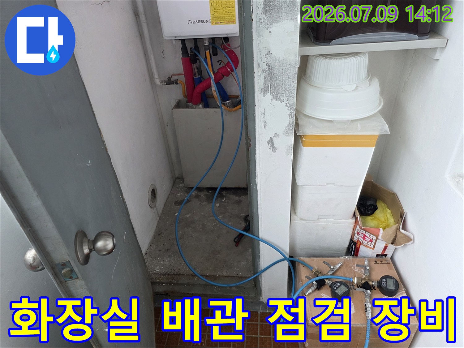 수도 계량기와 연결된 노출 배관에 압력 게이지를 설치하여 테스트하는 모습