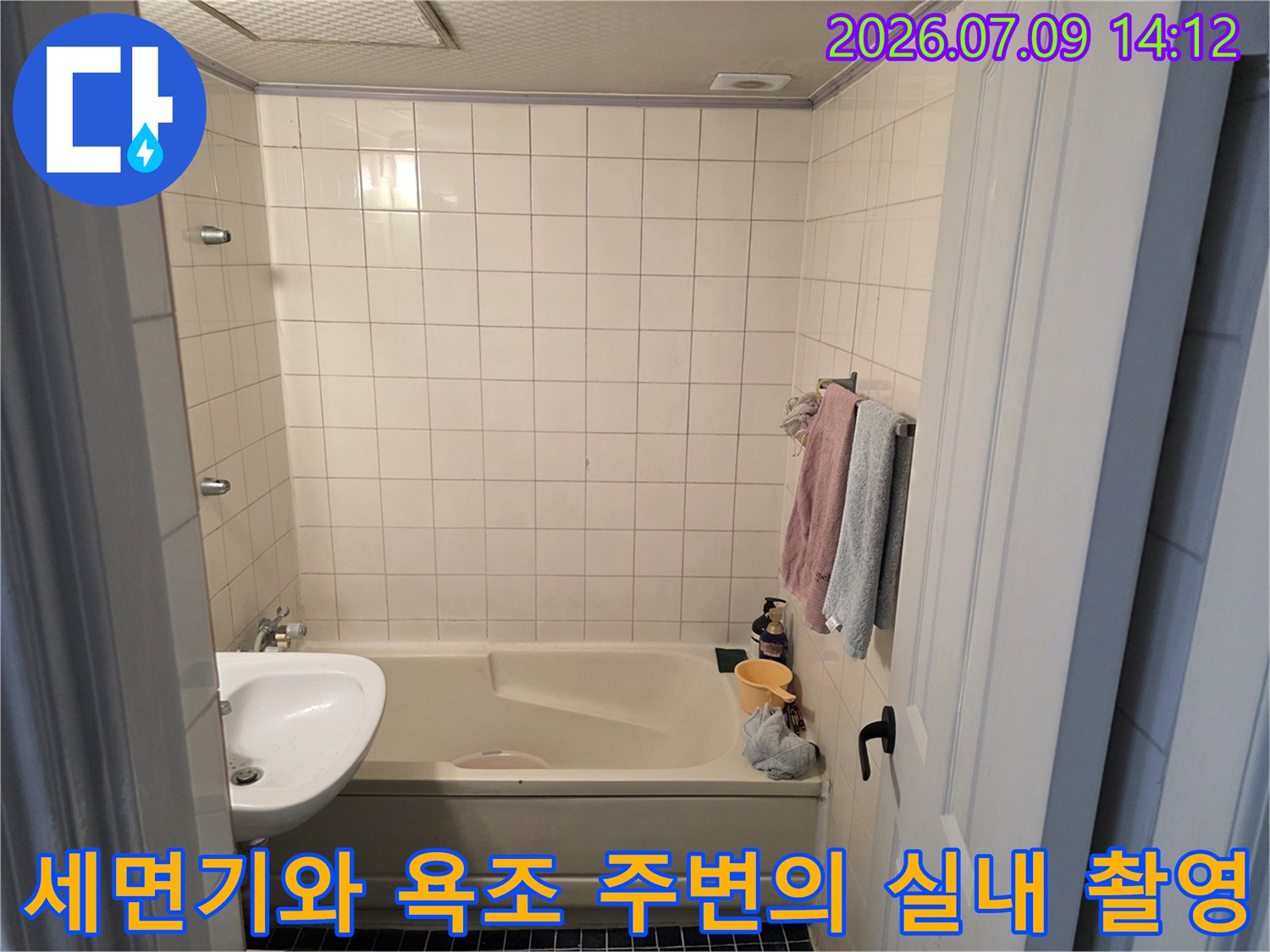 욕실 내부에 위치한 세면기 및 욕조와 타일 벽면을 촬영한 점검용 사진