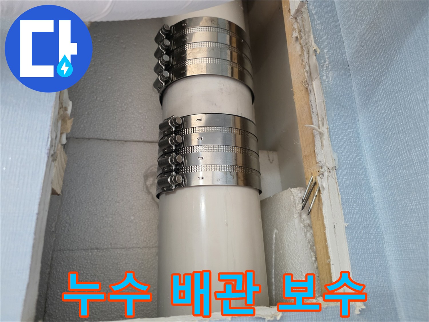 금속 밴드로 조여진 하얀색 PVC 배관 부위
