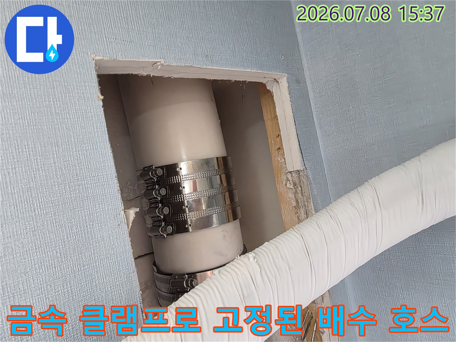 벽면 절개 부위에 위치한 금속 밴드 처리된 에어컨 드레인 파이프