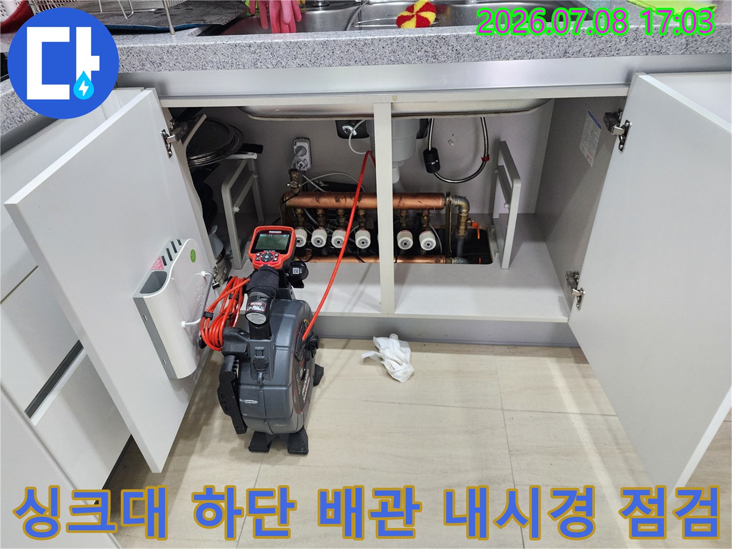 싱크대 아래 공간에서 전문 장비로 배관을 정밀하게 조사하는 모습