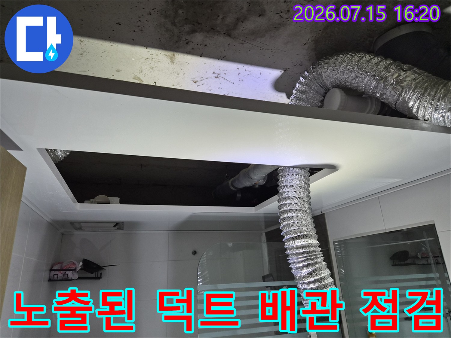 은색 단열재로 감싸진 굴곡진 배관과 화장실 천장 내부 구조를 촬영한 사진