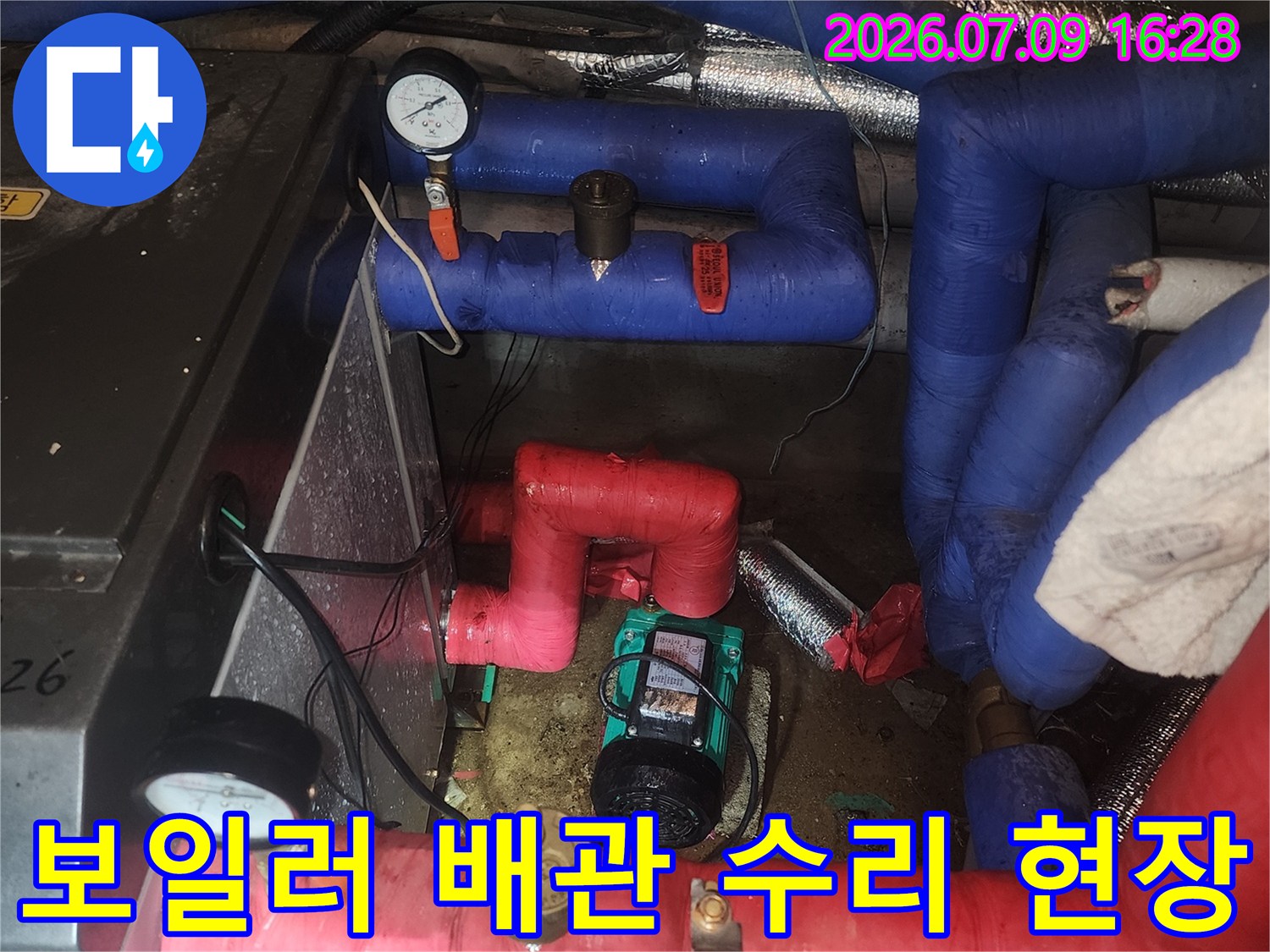 파란색과 빨간색 단열재가 씌워진 보일러 시스템용 배관들