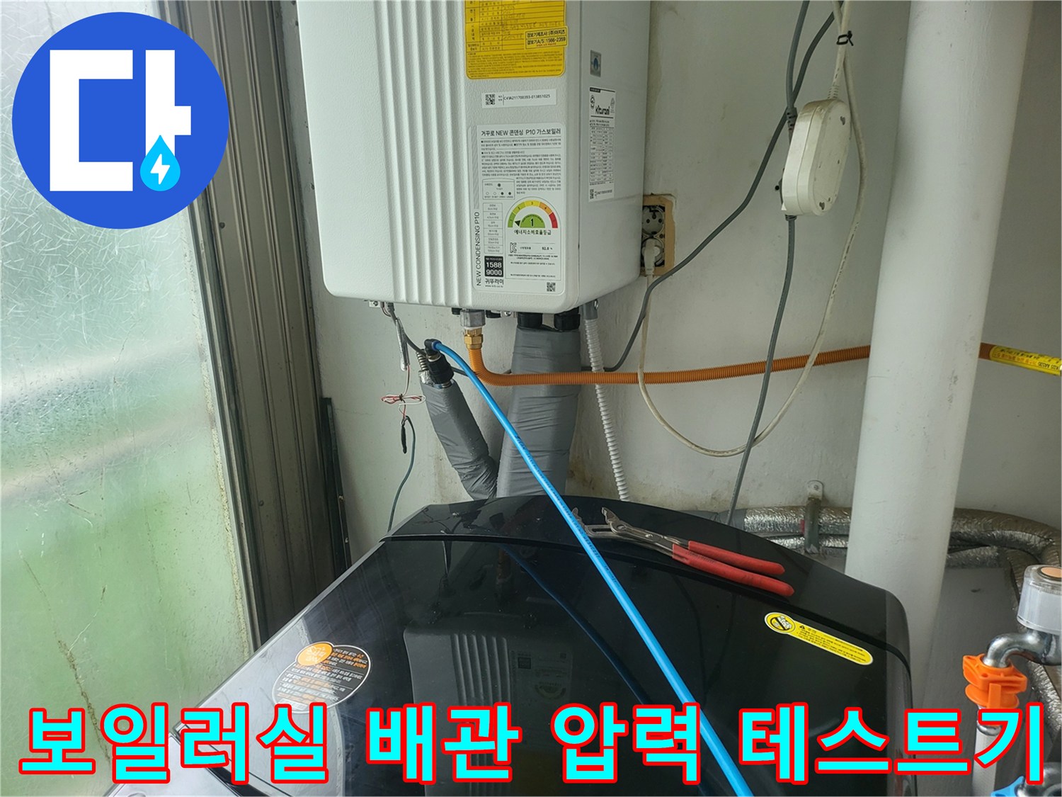 보일러 하단 배관에 연결된 파란색 호스와 압력 측정 장비의 모습입니다.