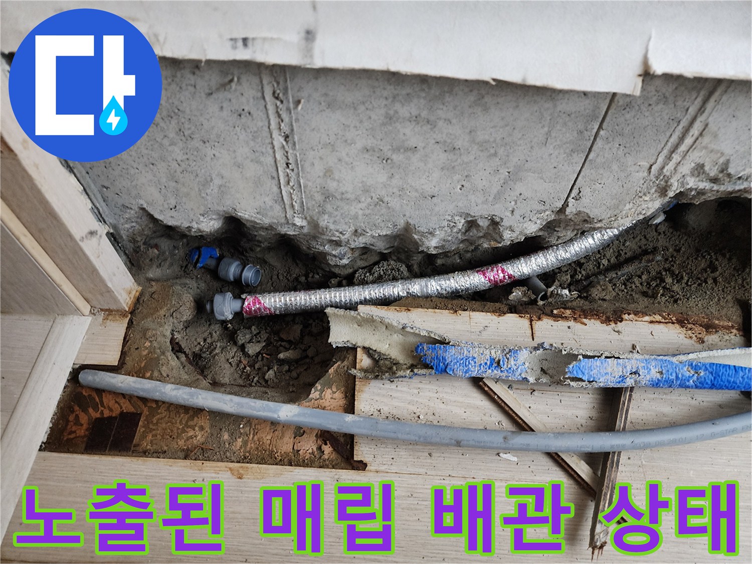 서초동 현장-시멘트 아래 노출된 은색 주름관과 파란색 배관의 모습
