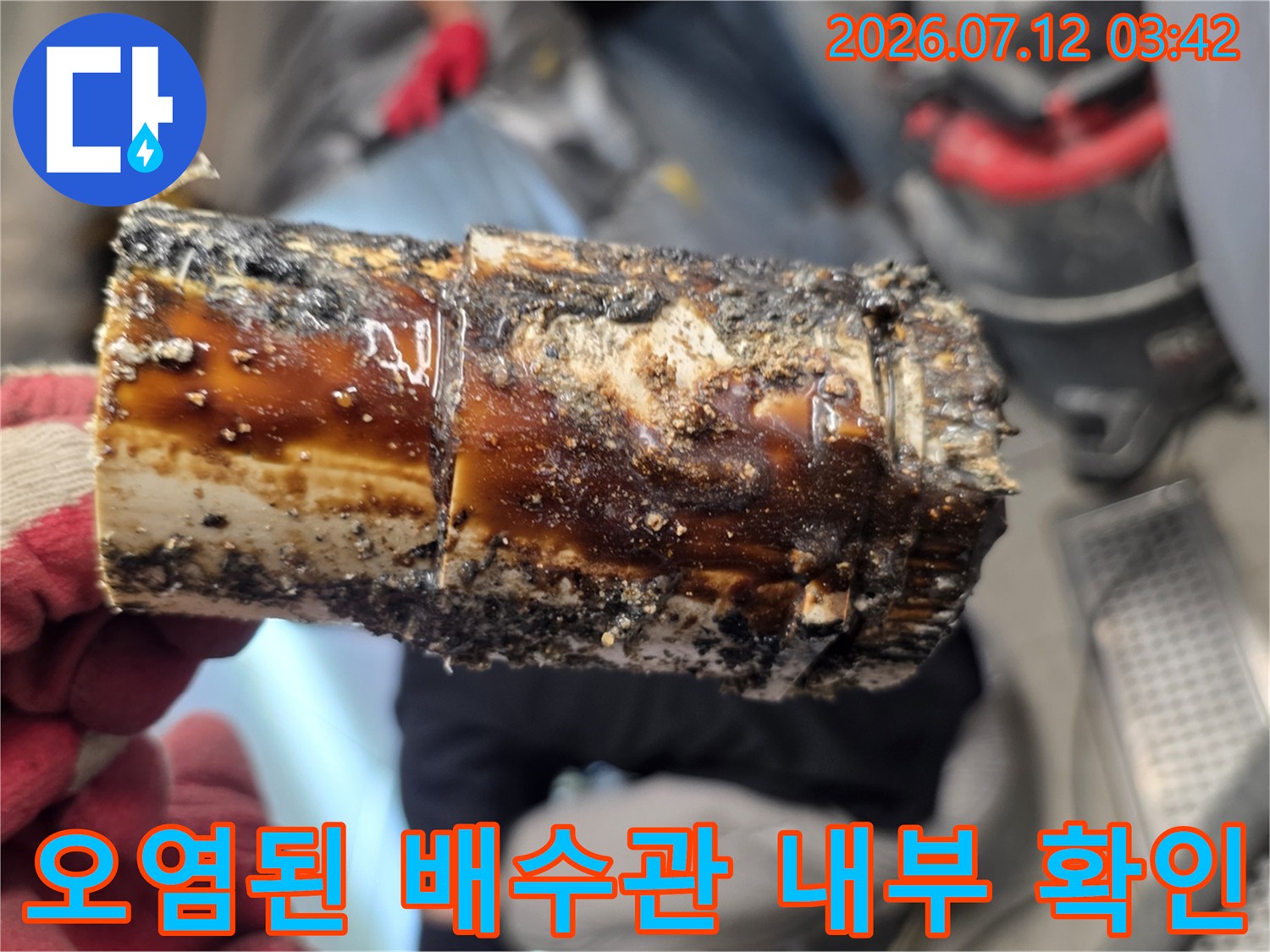 내부 기름 슬러지가 가득 찬 노후된 배수관 단면