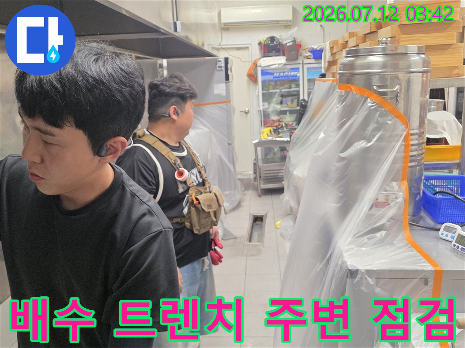 대형 저장 탱크 옆 배송 및 배수 경로를 체크하는 전문 기술자