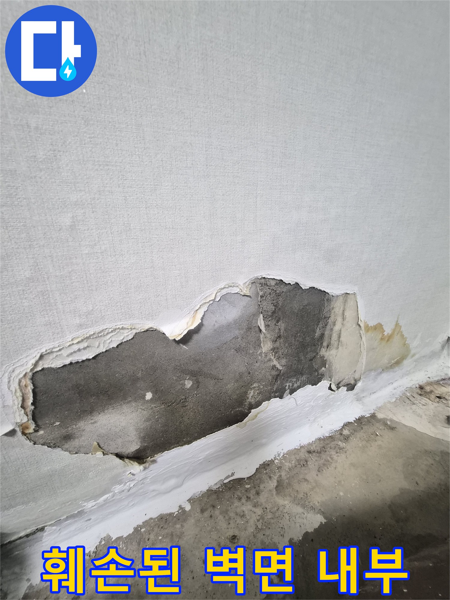 물에 젖어 변색된 시멘트벽과 뜯겨나간 벽지