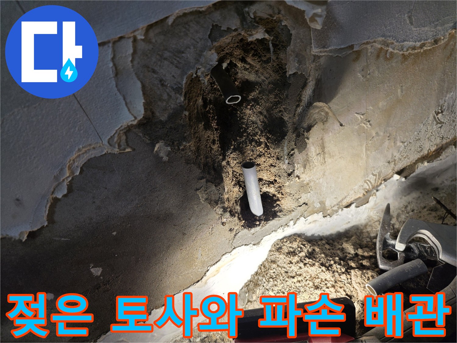 물에 젖은 흙과 함께 드러난 문제의 흰색 수도 배관