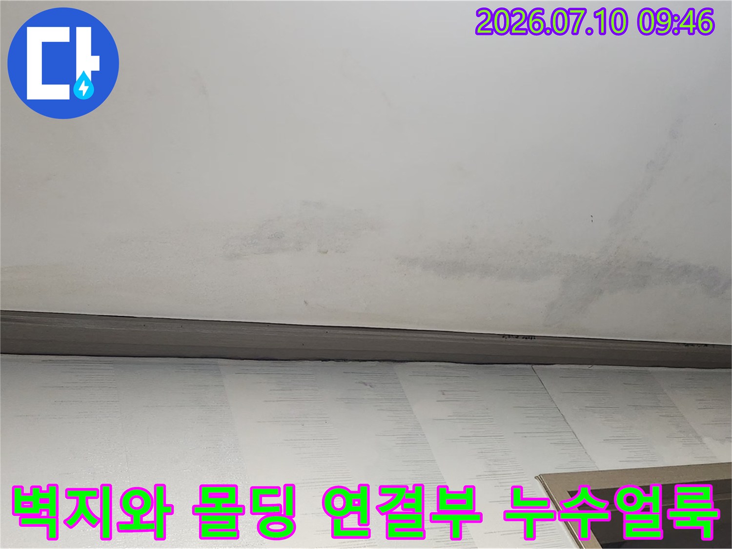 베이지 색상의 벽지에 묻어난 천장 물샘 흔적과 얼룩