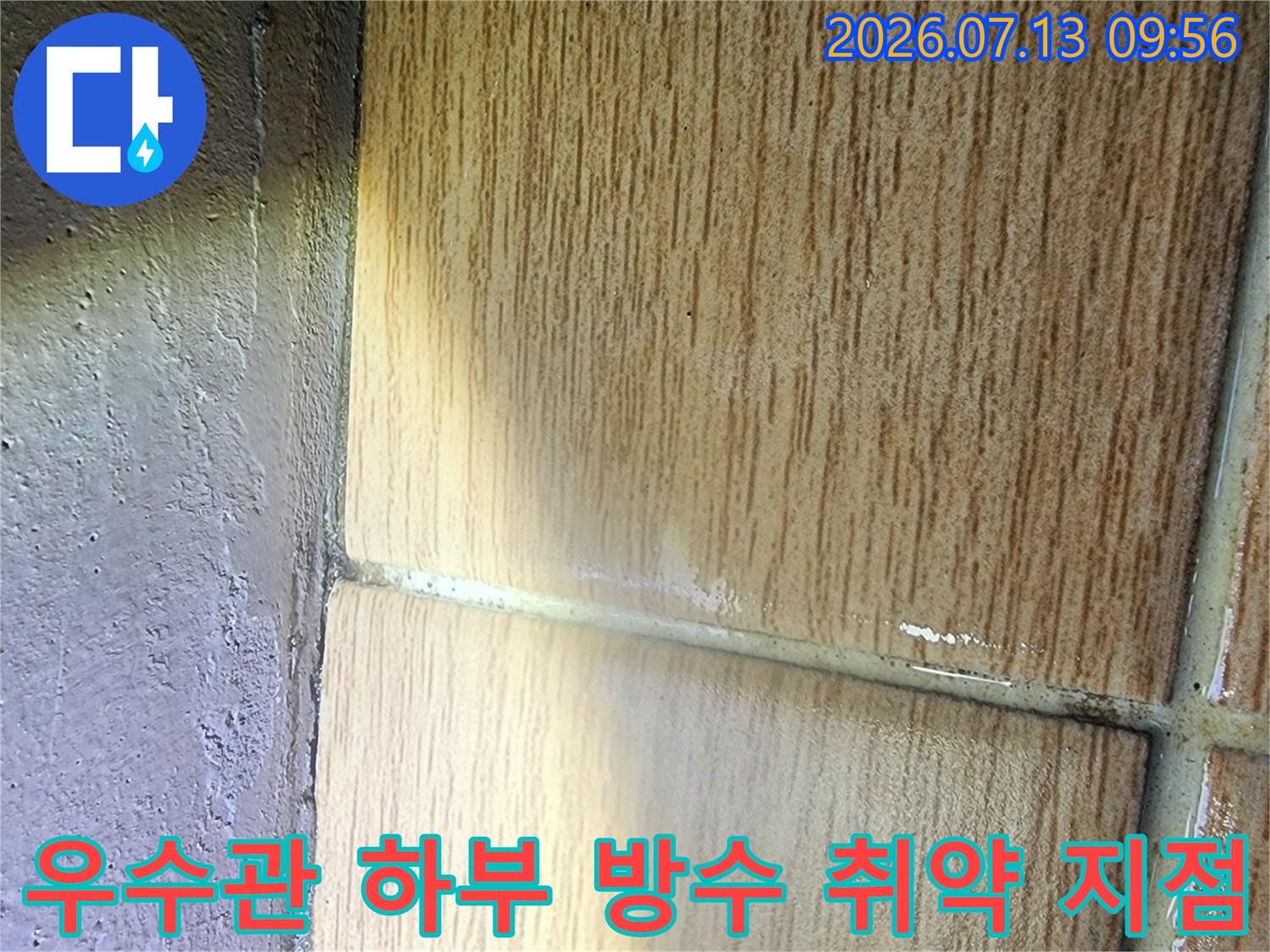 타일 줄눈이 벌어진 우수관 주변의 근접 촬영 사진