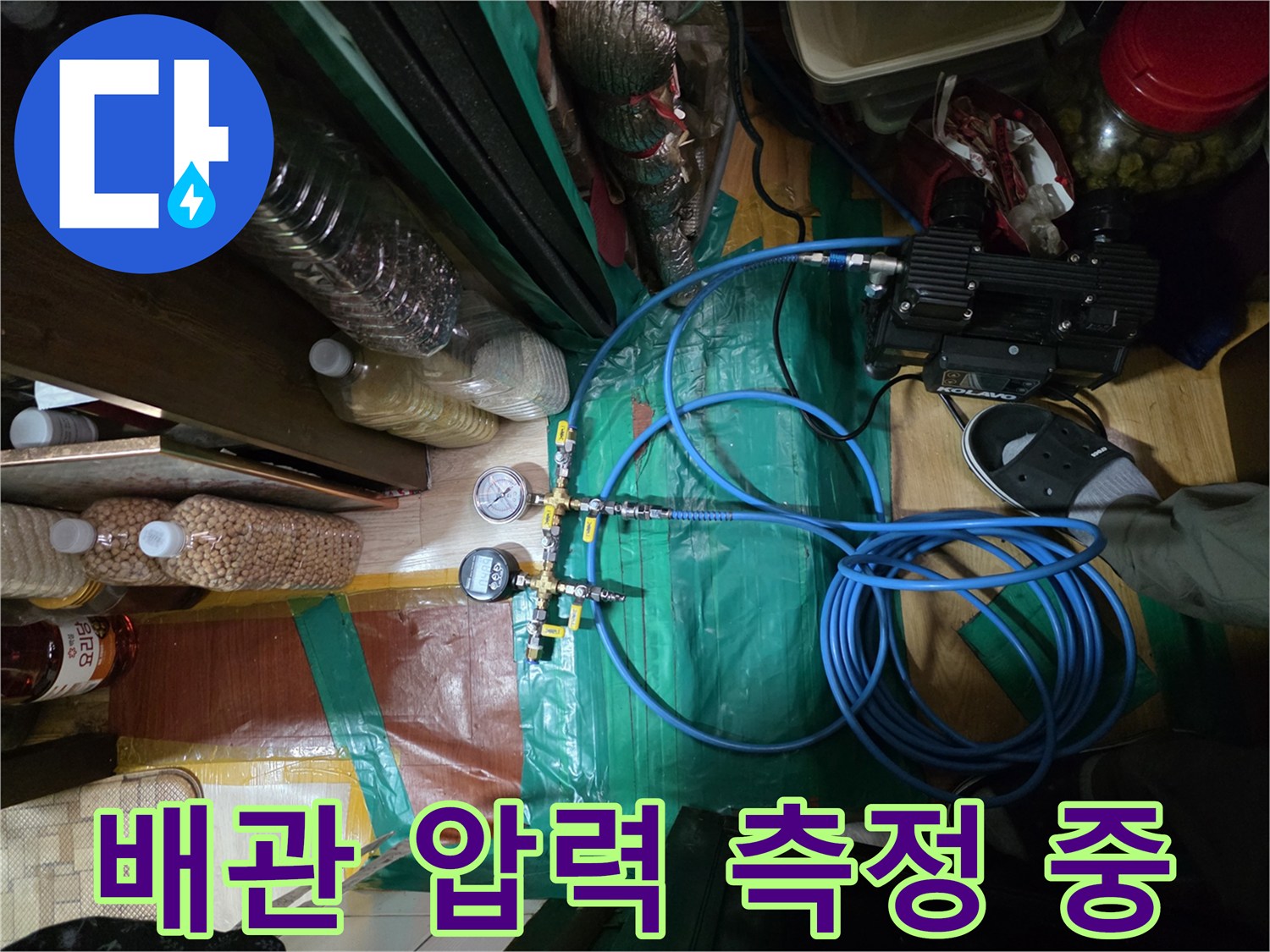 디지털 압력계와 연결된 파란색 배관 호스 모습