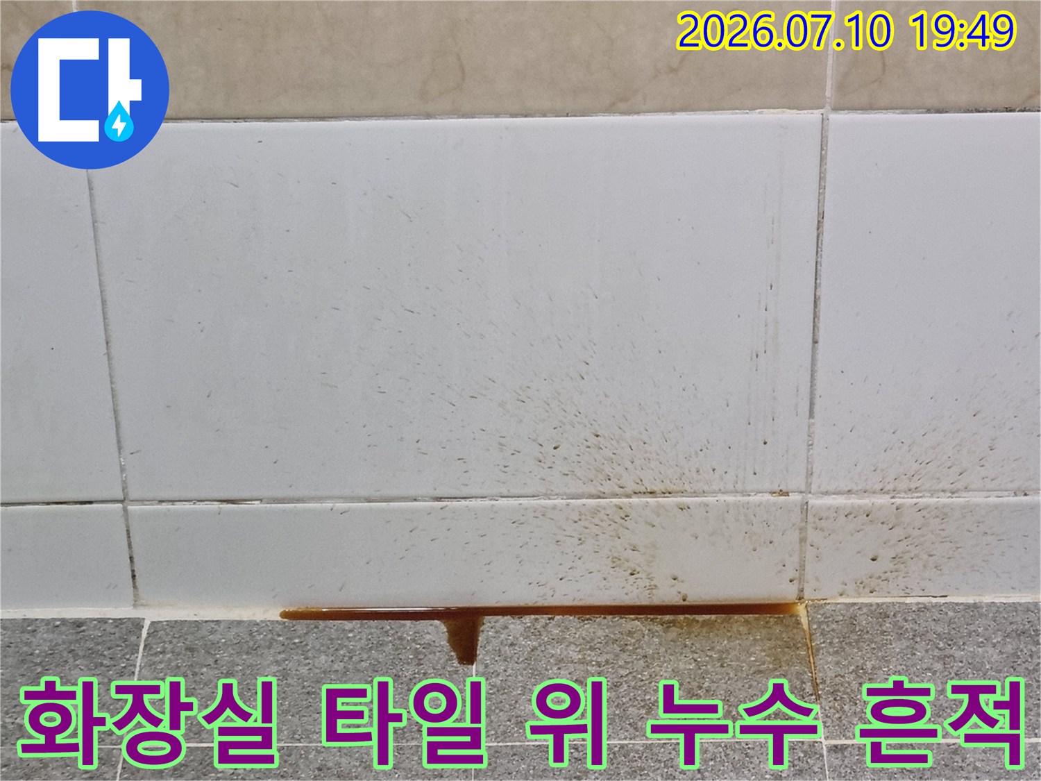 타일과 하부 구조물 사이로 흘러내린 갈색 수분 자국
