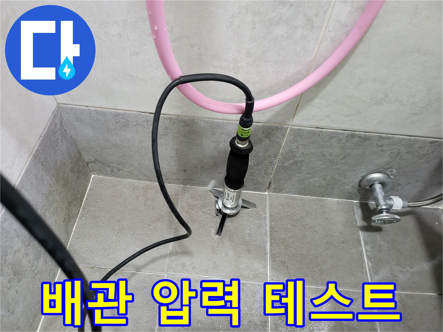 화장실 타일 바닥에 연결된 배관의 공압 테스트 모습