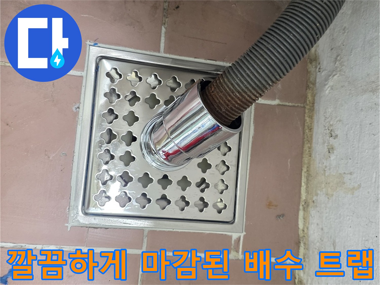 타일 바닥에 설치된 스테인리스 재질의 배수구 거름망과 호스