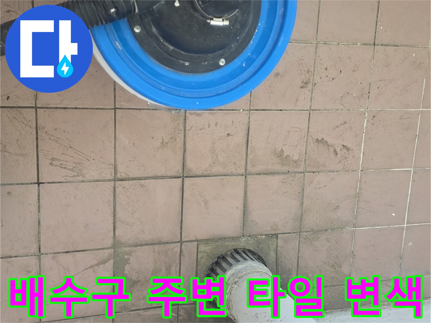 하수구 입구 주변의 젖은 타일 상태를 보여주는 사진