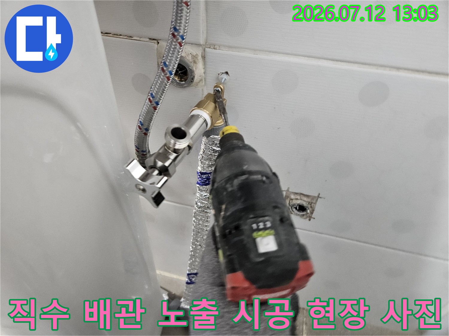 세면대 쪽으로 연결되는 직수 배관에 보온재를 입히고 고정하는 작업 장면