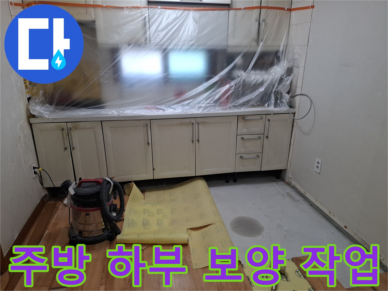 싱크대 밑 공간 - 비닐과 보호재로 덮인 현장 상황
